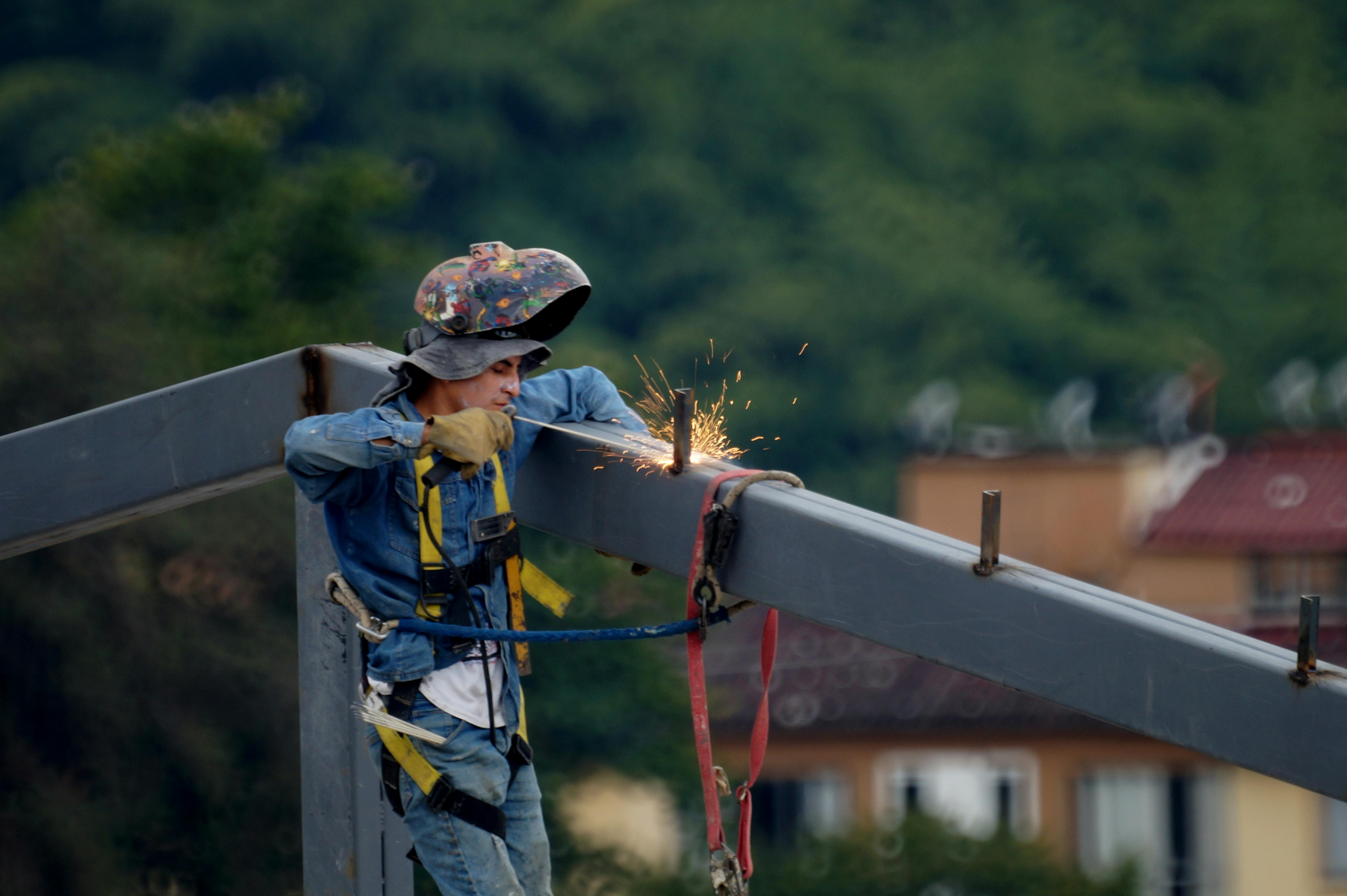 Man on lift welding iron beam